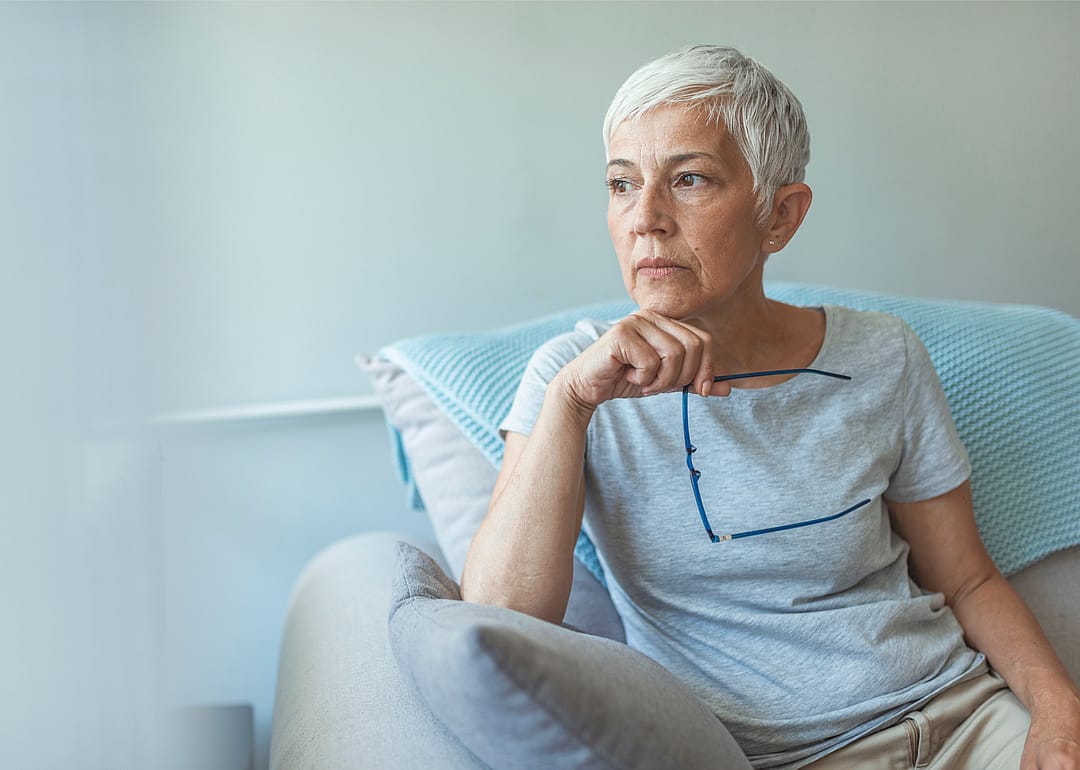 Concerned middle aged woman sitting in chair.
