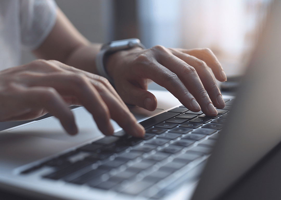 Hands typing on laptop computer keyboard