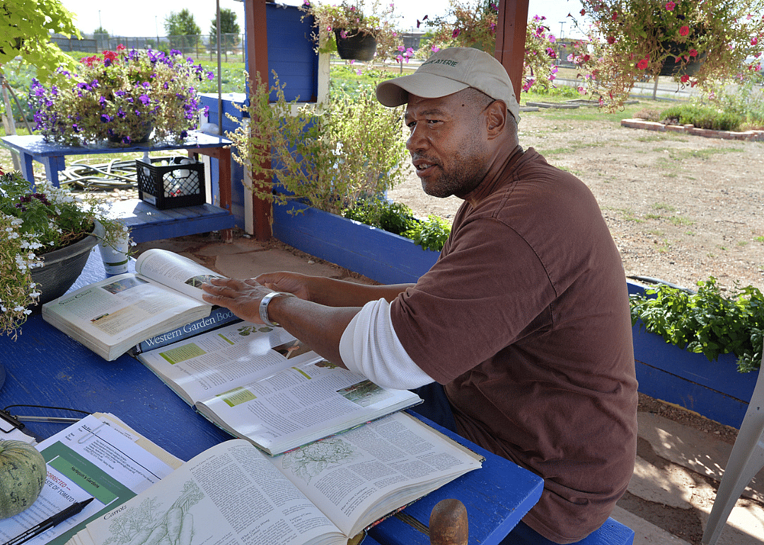 An inmate consults garden books at Boulder County Jail’s organic garden