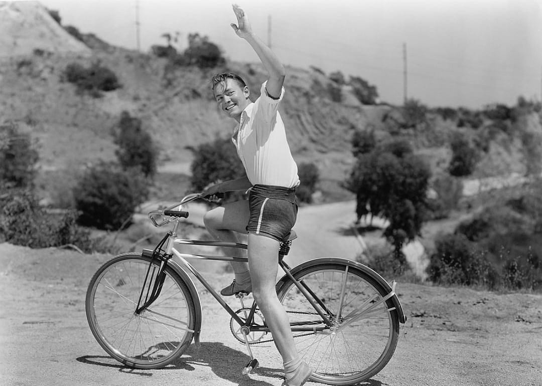 Man waving on bicycle.
