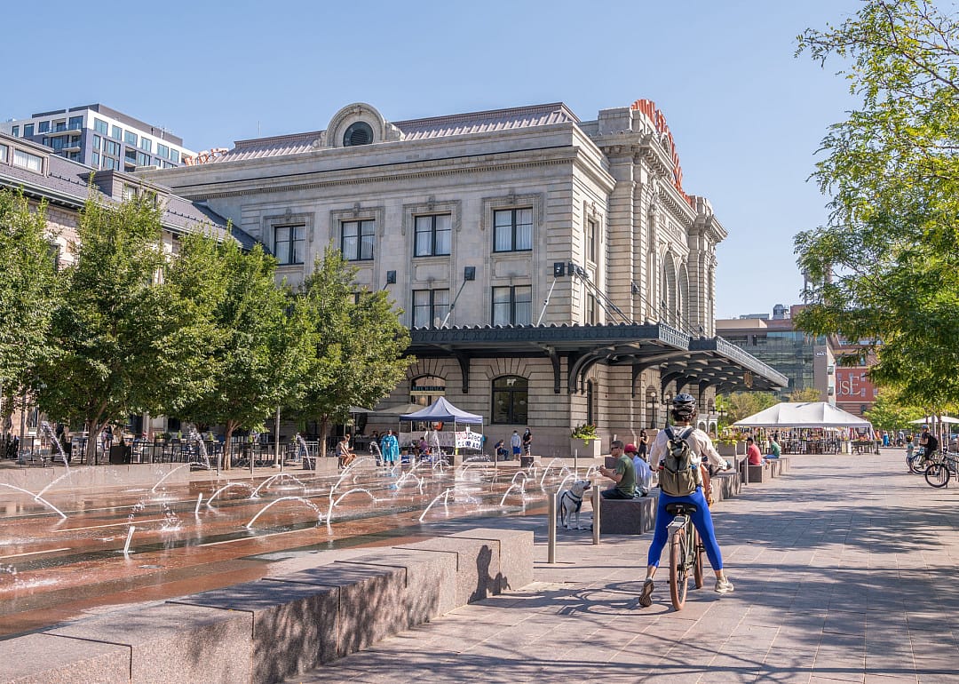 A person rides a bicycle in the plaza at Union Station in Denver