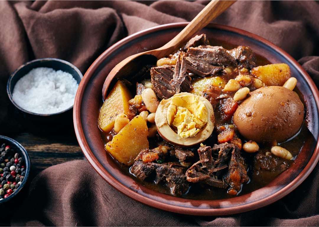 A large bowl of dafina with a wooden spoon.