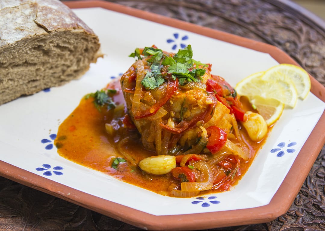 Chraime on a plate with a piece of bread.