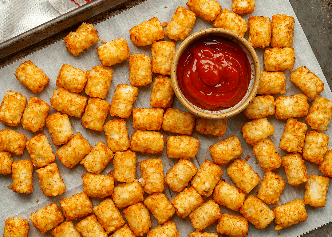 Tater tots with ketchup on sheet pan.