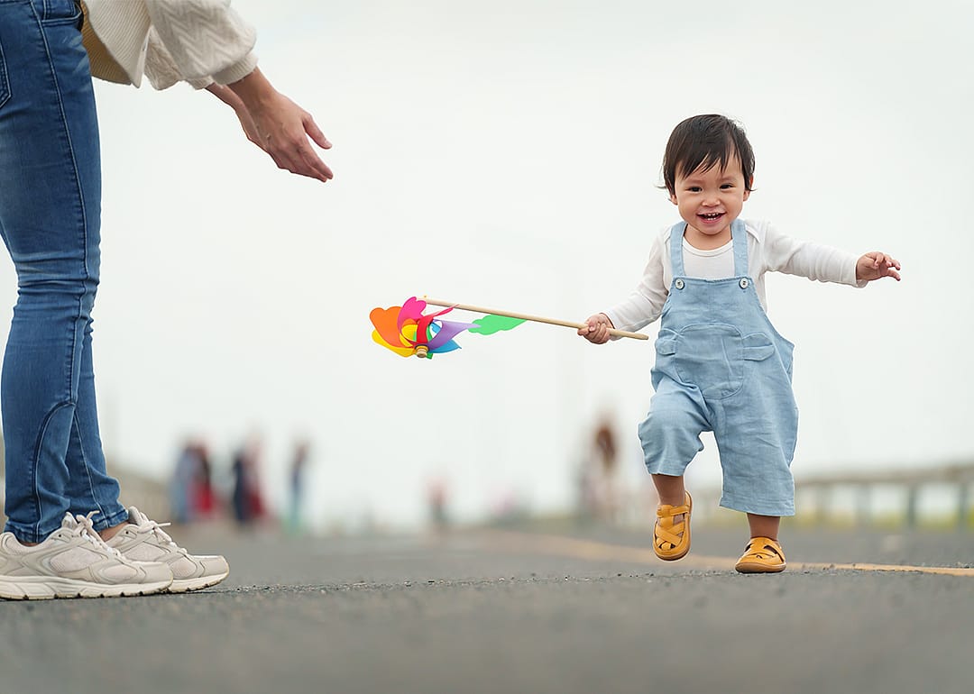 Infant baby learn walking first step on a pathway.