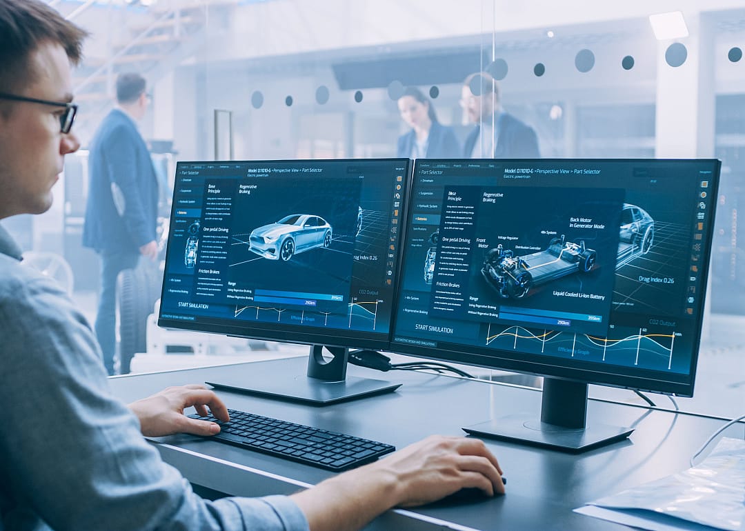 Person working on computer in automotive design office.