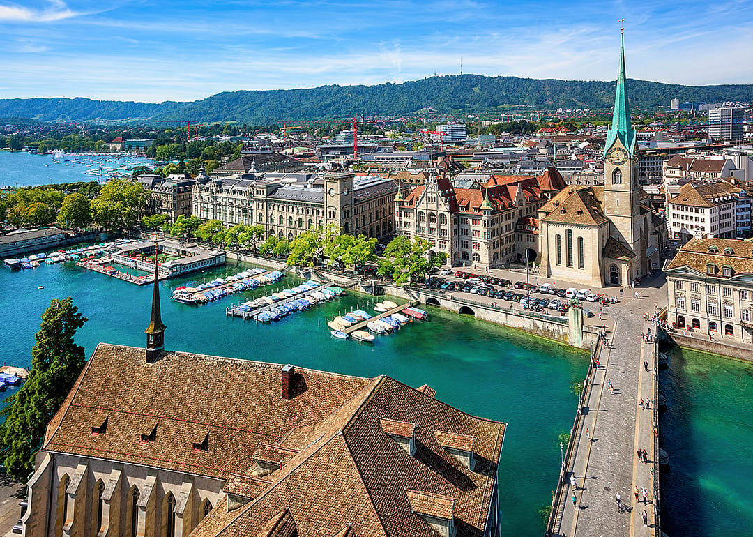 Elevated view of Zurich’s Old Town, Fraumunster church, and bridge over the Limmat river.
