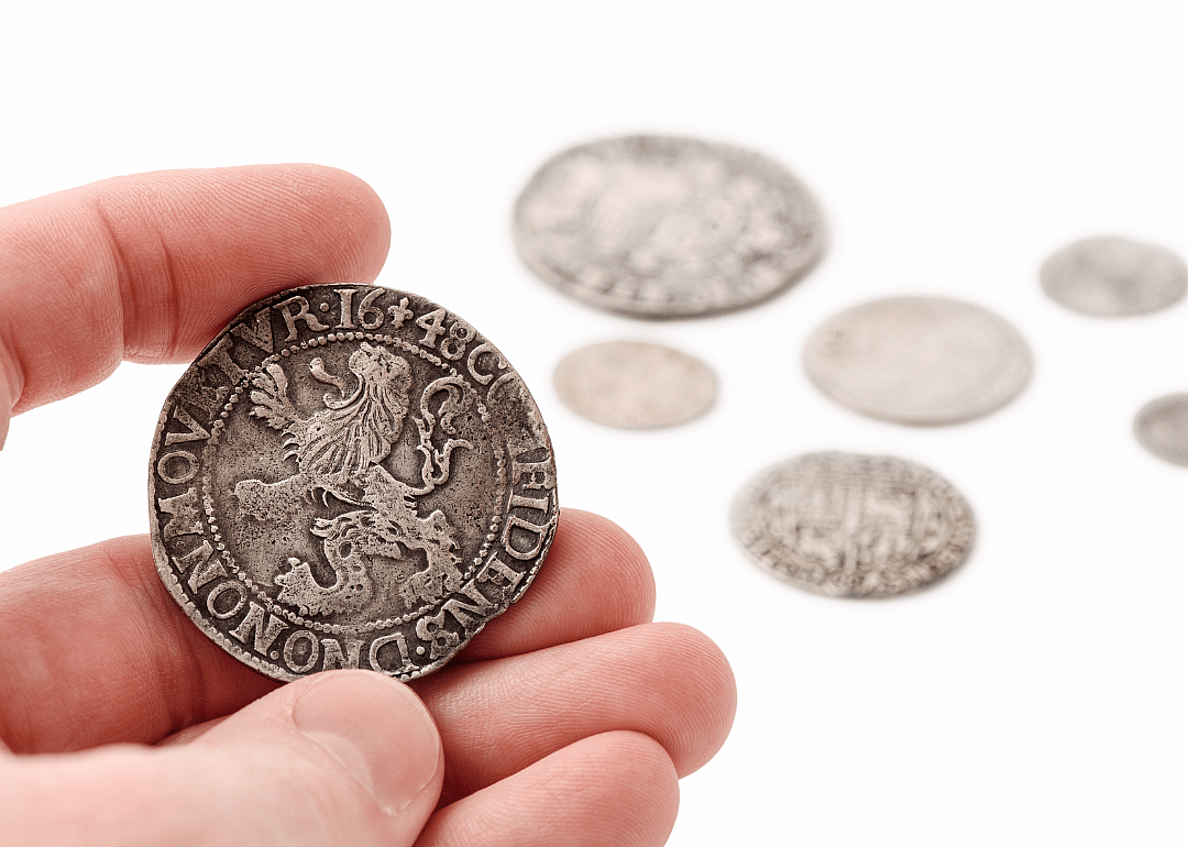 Hand holding silver thaler.