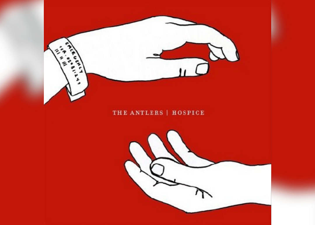 The album is an illustration of two white hands on a red background.