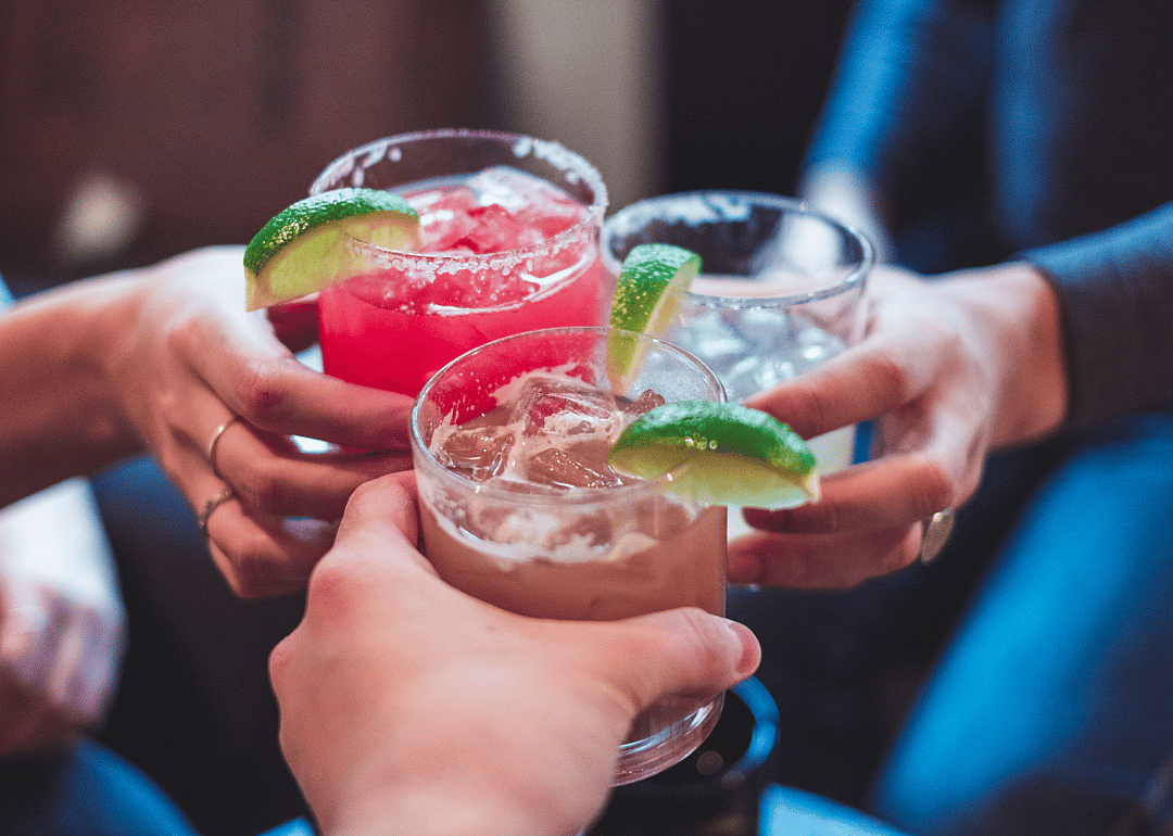 Friends toasting with drinks at home.