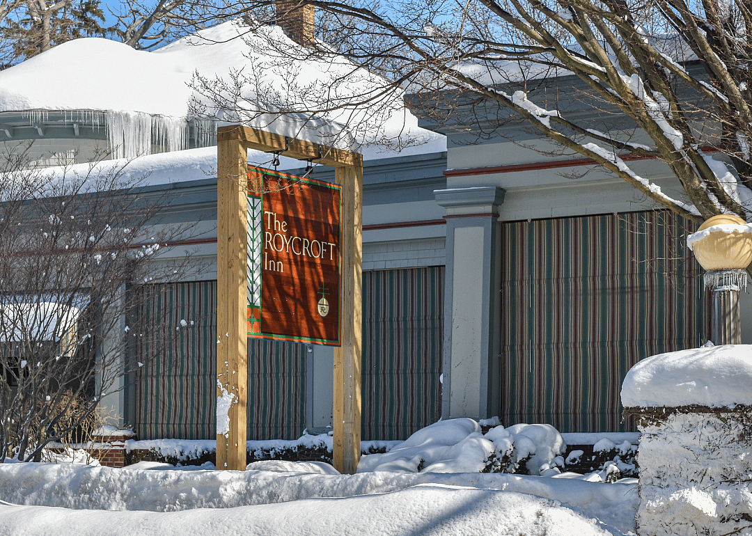 The Roycroft Inn sign outside snowy building.