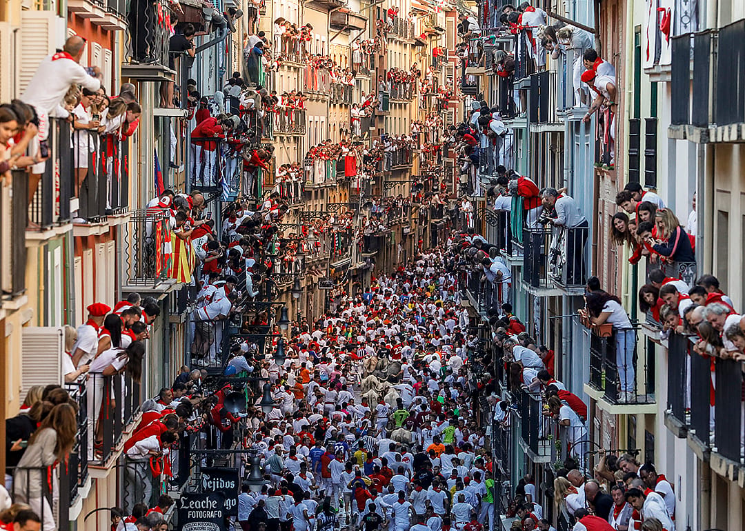 Crowds fill the streets, watching the San Fermin Festival in Pamplona.