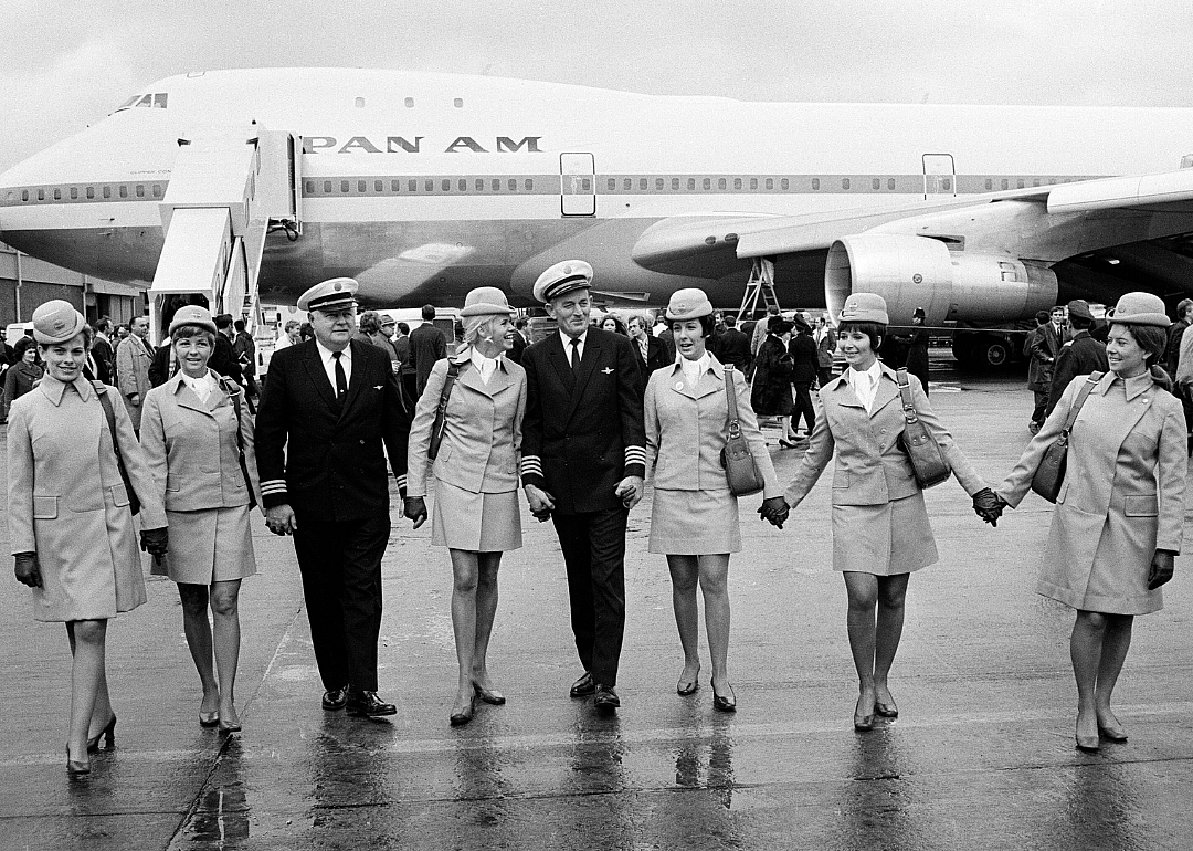 Pilots and crew stand in front of 747 passenger jet at Heathrow Airport.