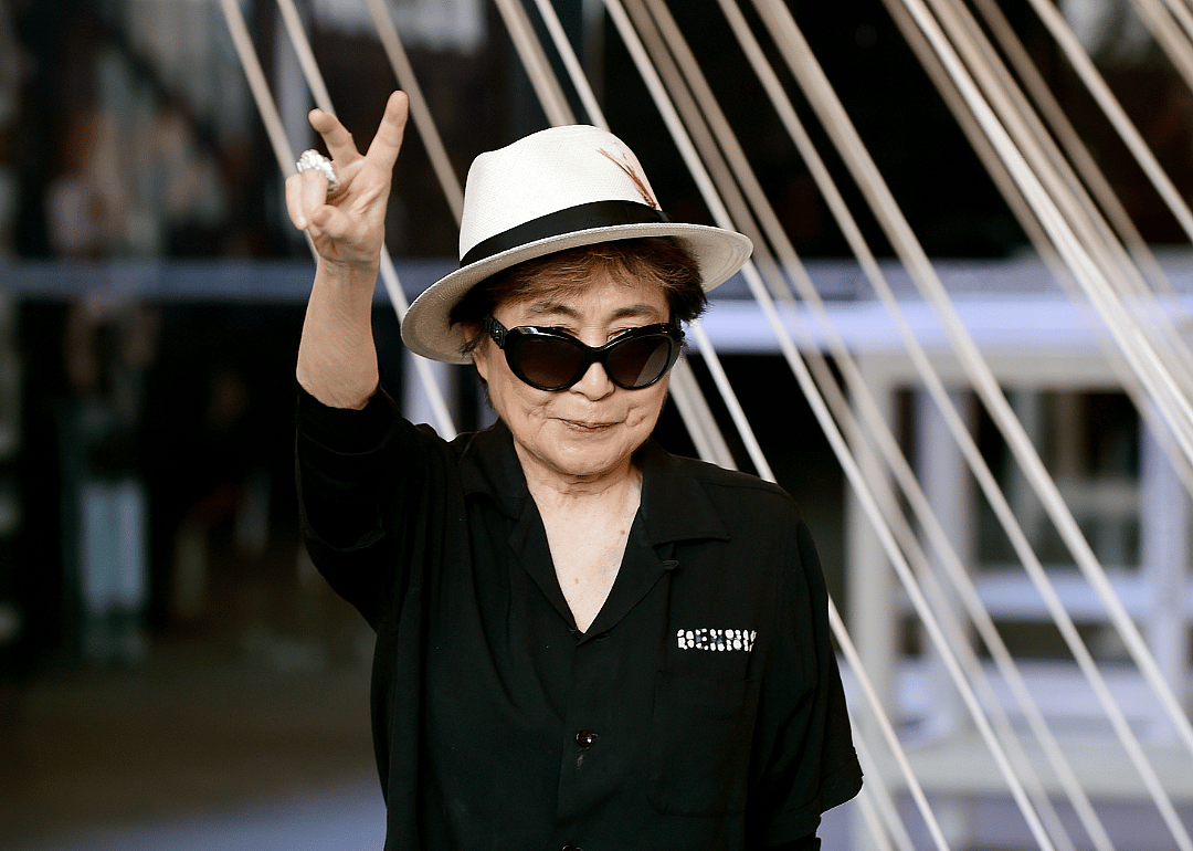 Yoko Ono gives the peace sign at an event.