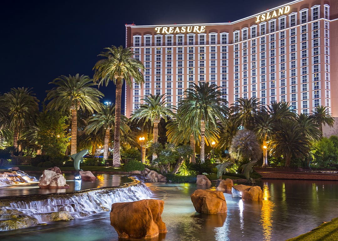 A view of the lagoon and main entrance of Treasure Island at night.