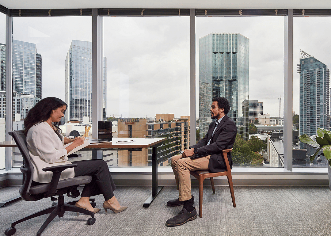 Two employees chatting in a modern office space