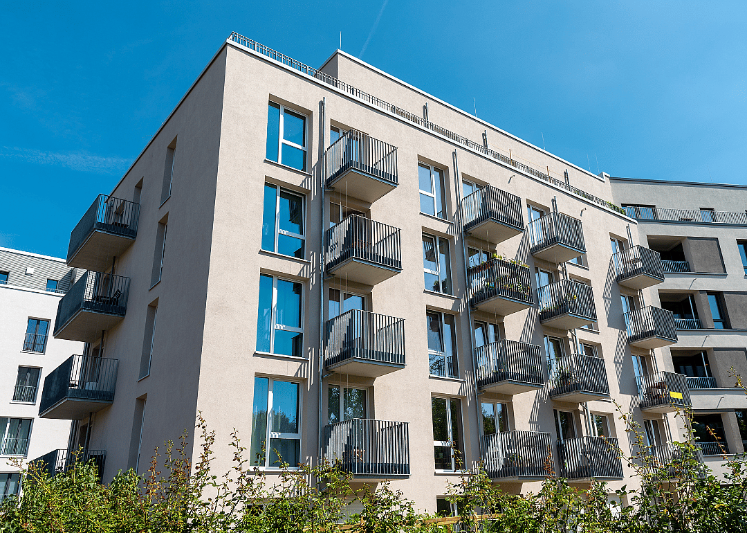 Exterior shot of a modern, mid-sized apartment building with balconies.