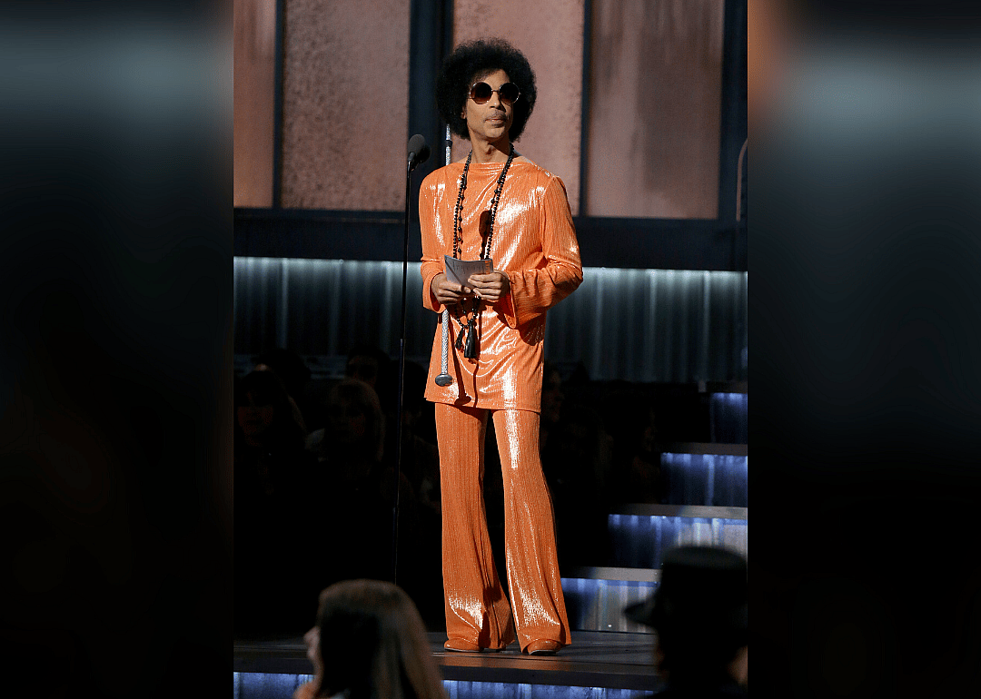 Princ e presents an award in a sequined orange outfit.