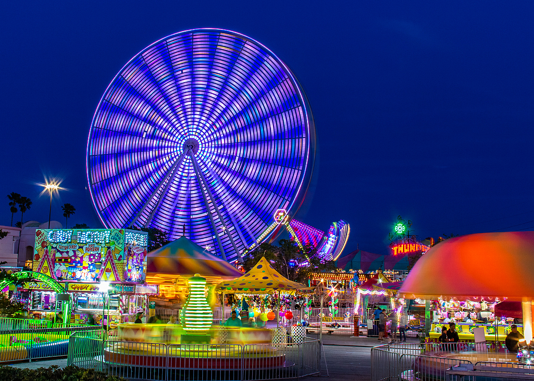 An amusement park with ferris wheel and rides at night.