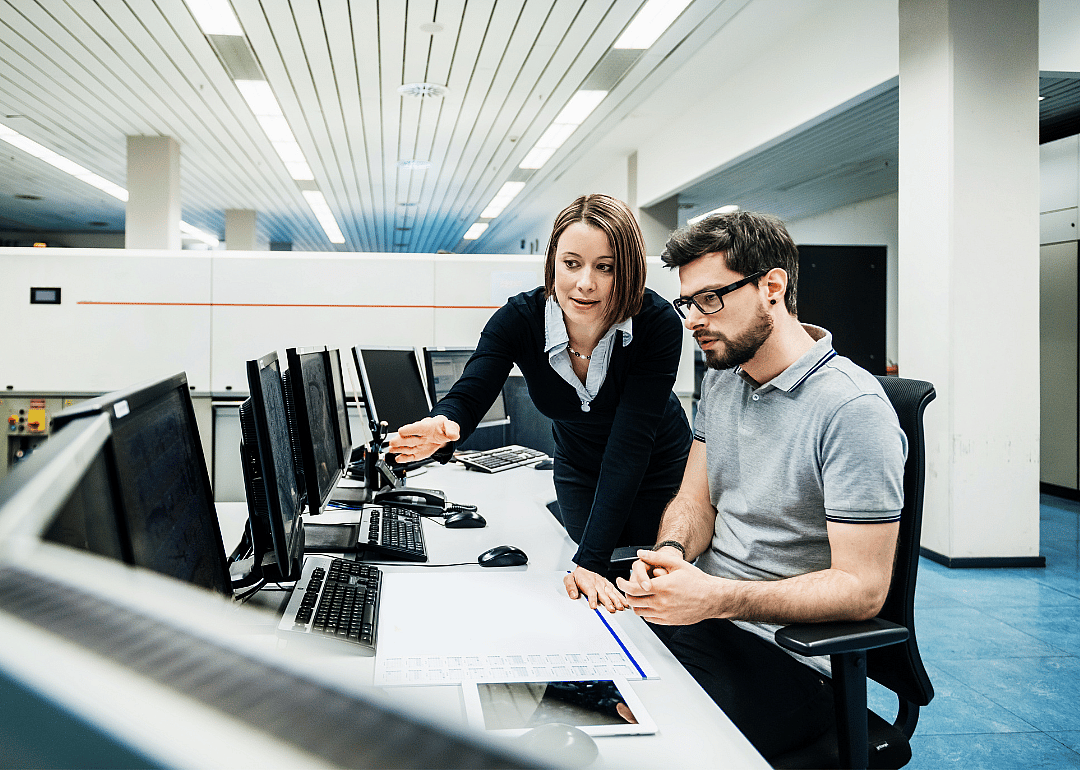 Two colleagues working at an office computer.