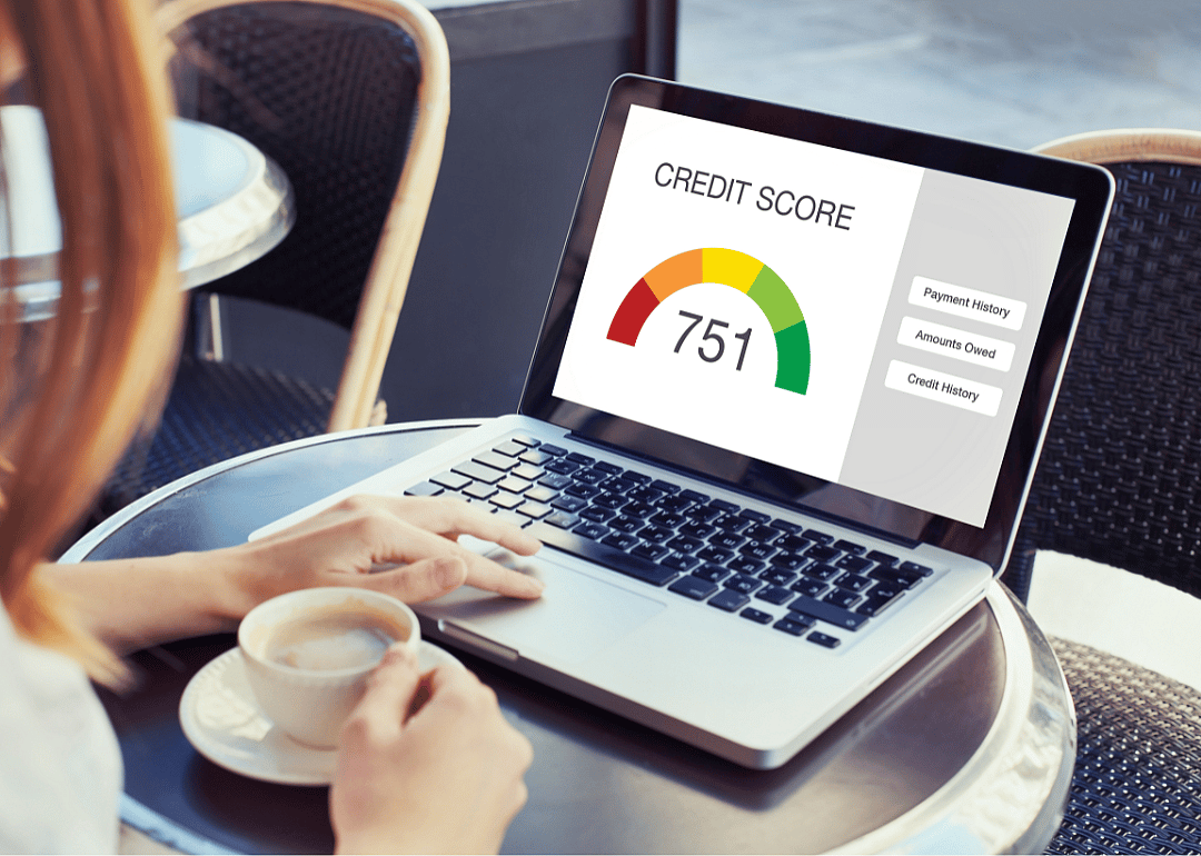 A laptop displays a credit score of 751.