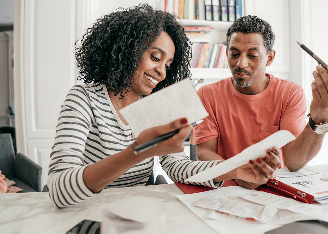 A couple review financial documents at a table.