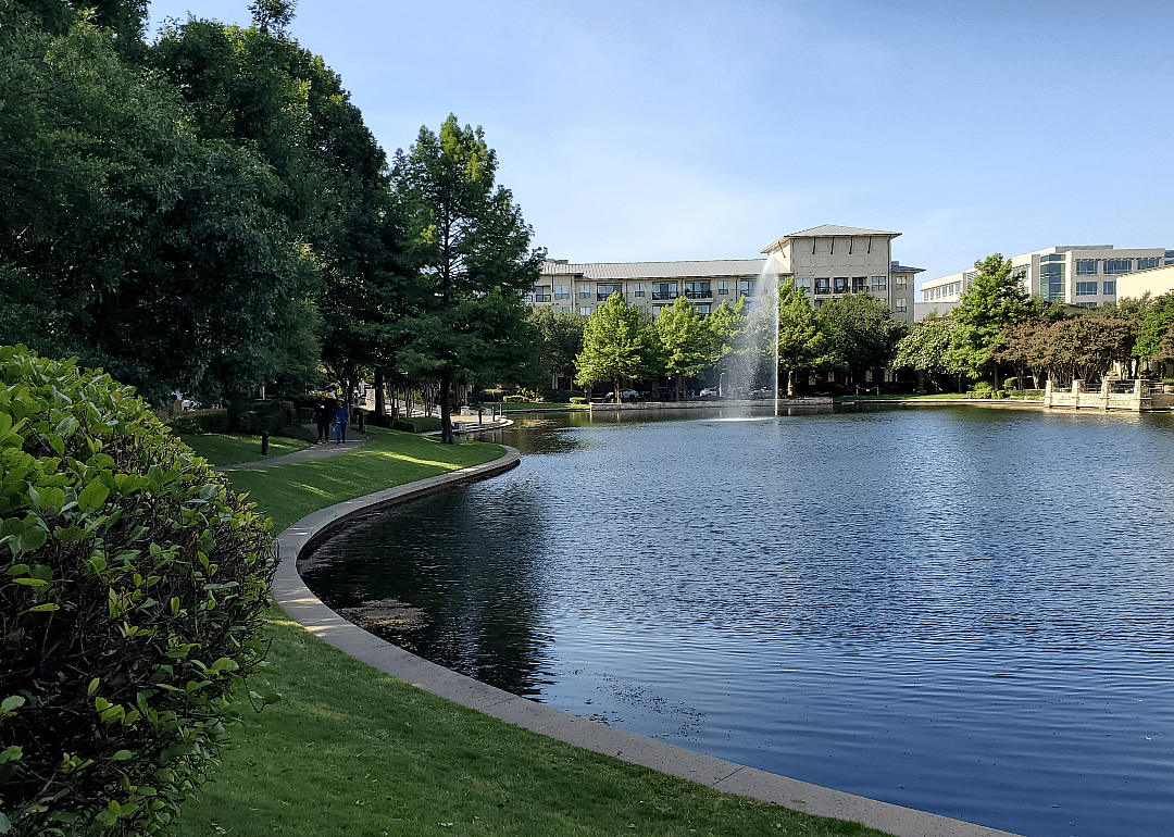 Tree-lined walking path near a lake in Frisco, Texas.