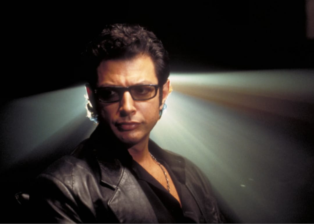 Jeff Goldblum in all black with a light shining behind him.