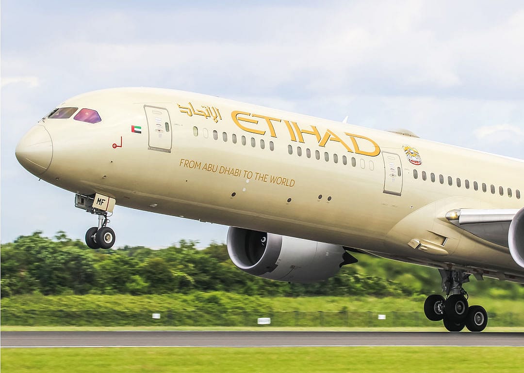 An Etihad Airways plane lifts off the runway.