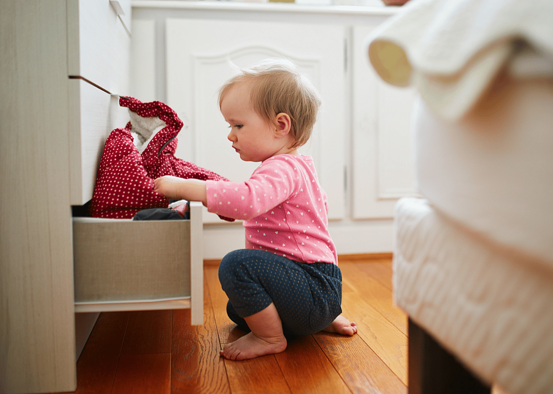 Baby rummaging through bottom drawer.