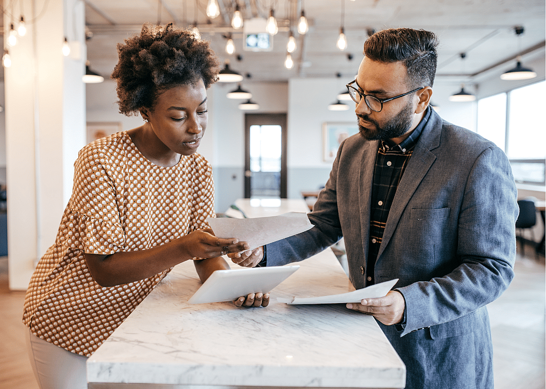 Two business owners review paperwork in an office.