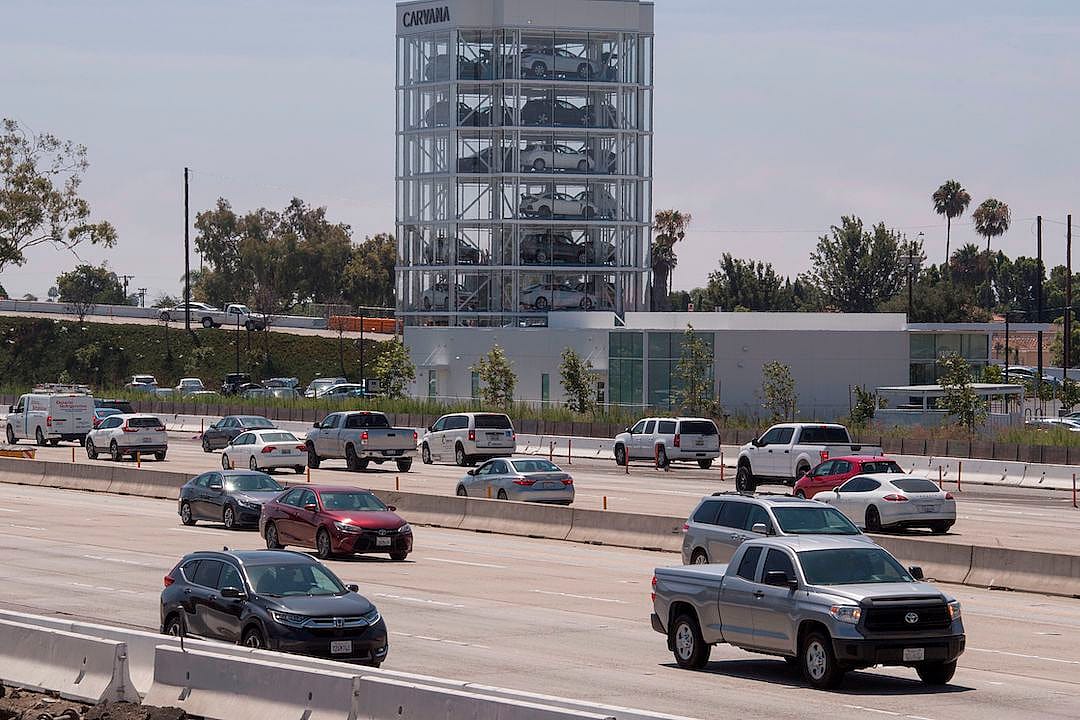 Cars driving past an eight-story Carvana car vending machine.