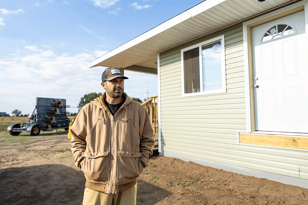 Danny Desjarlais stands next to a newly built duplex