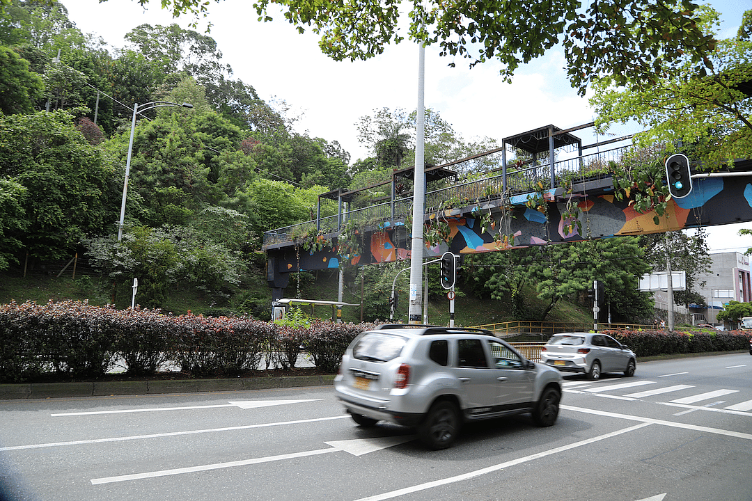 cars driving on the road in medellin, colombia near trees and plants