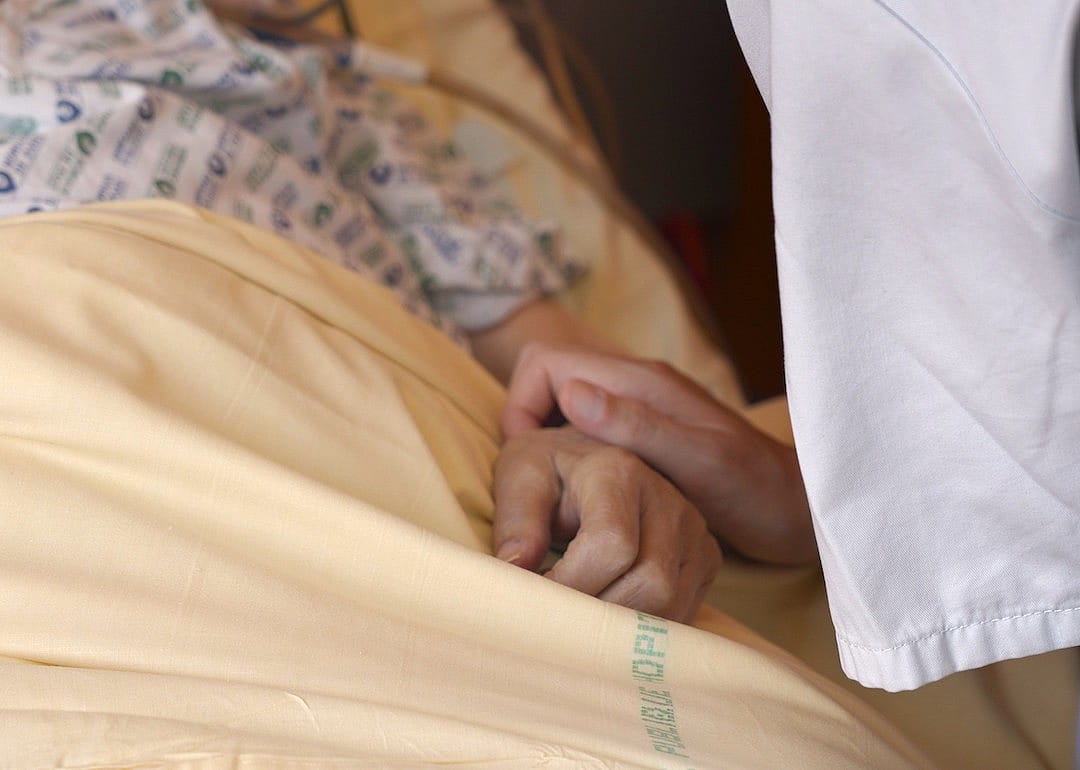 Doctor holding patient's hand in the 2023 movie 'Our Body.'