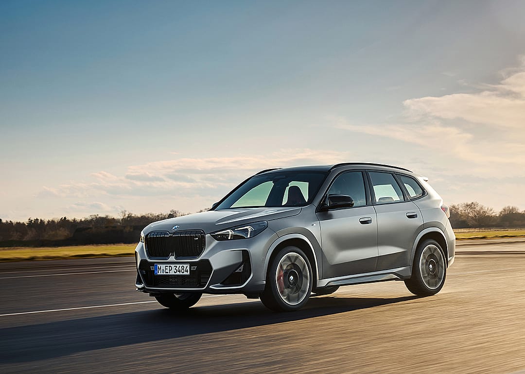 A silver metallic model of the BMW X1 driven on the road.