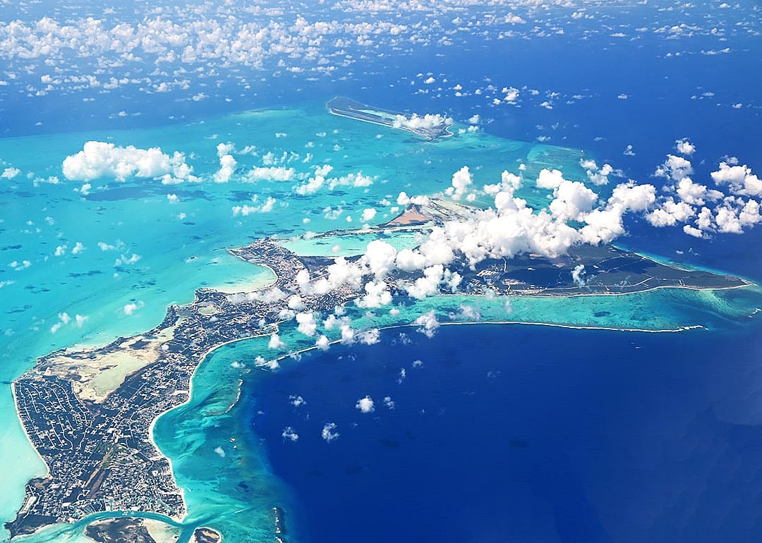 Aerial view of Turks and Caicos surrounded by turquoise and deep blue sea.
