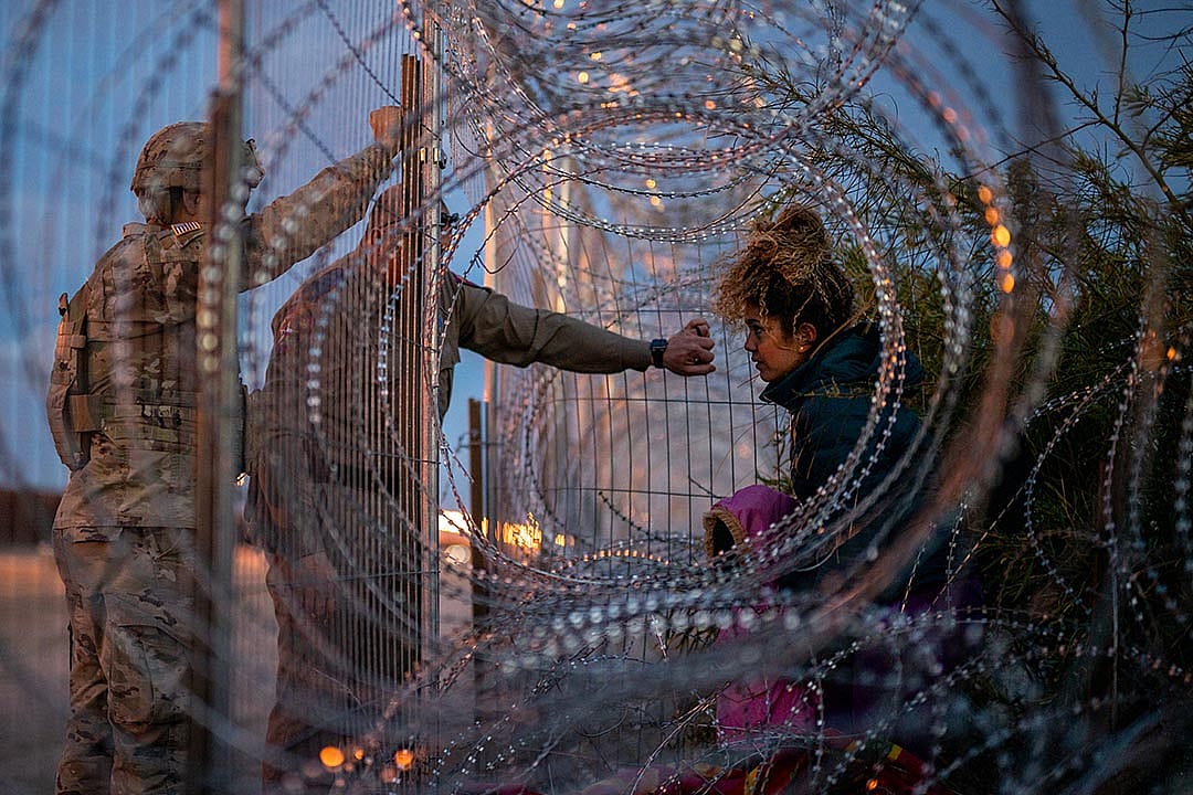 Photographed through concertina wire, Eliana, 22, a migrant from Venezuela, holds her daughter Crismarlees, 3, while being denied entry after attempting to cross through concertina from the U.S. side of the Rio Grande river on March 26, 2024 in El Paso, Texas.
