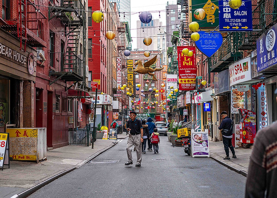 Pedestrians and businesses in a Chinatown street in New York City.
