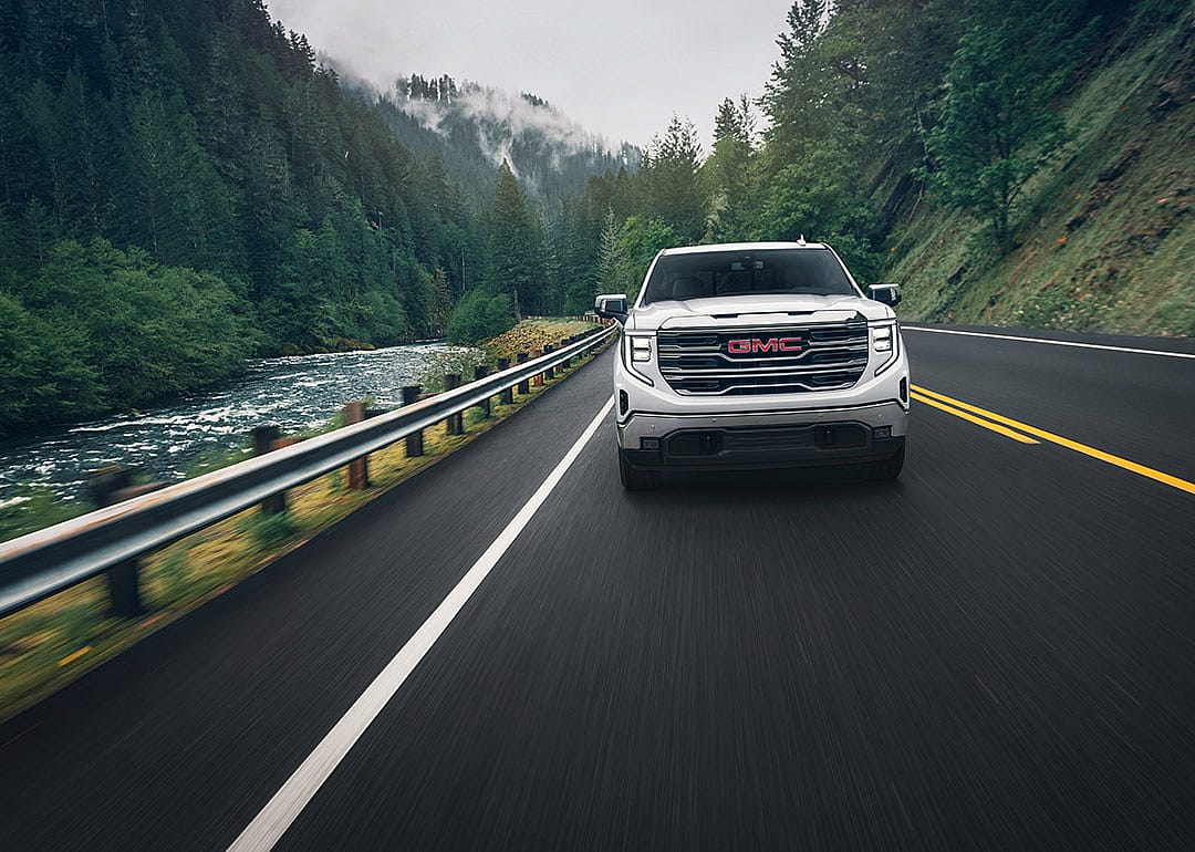 A front view of a white 2025 GMC Sierra 1500 on the road.