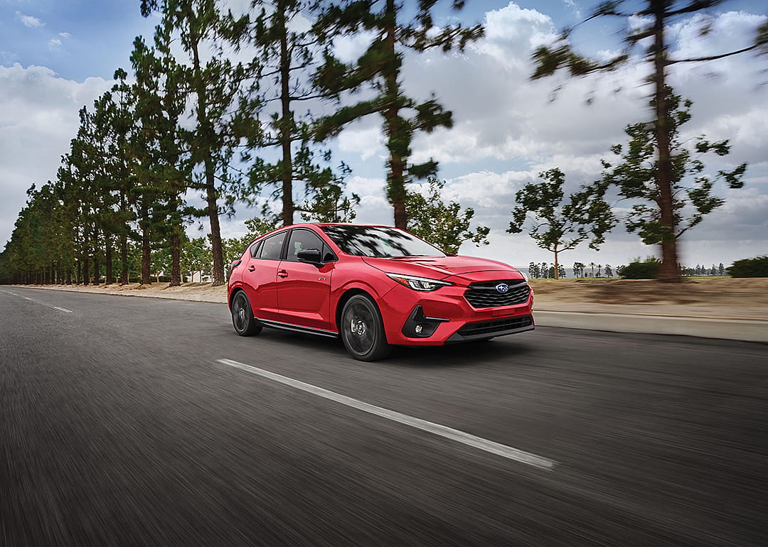 A red 2025 Subaru Impreza on the road.