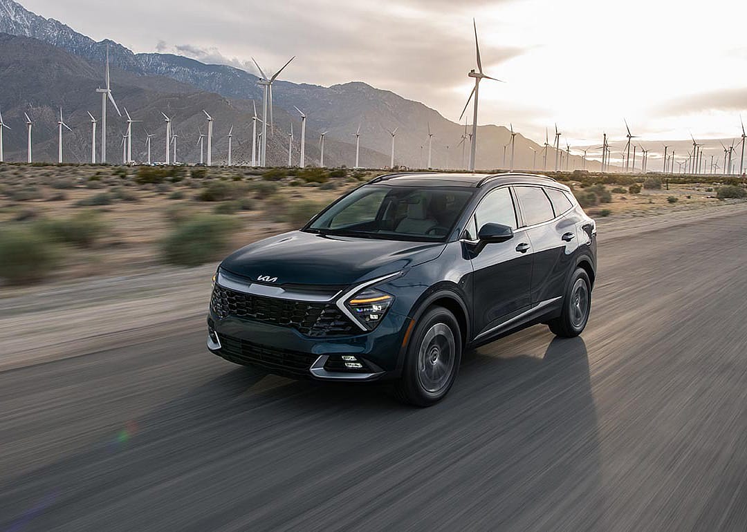 A black 2025 Kia Sportage Hybrid on the road.