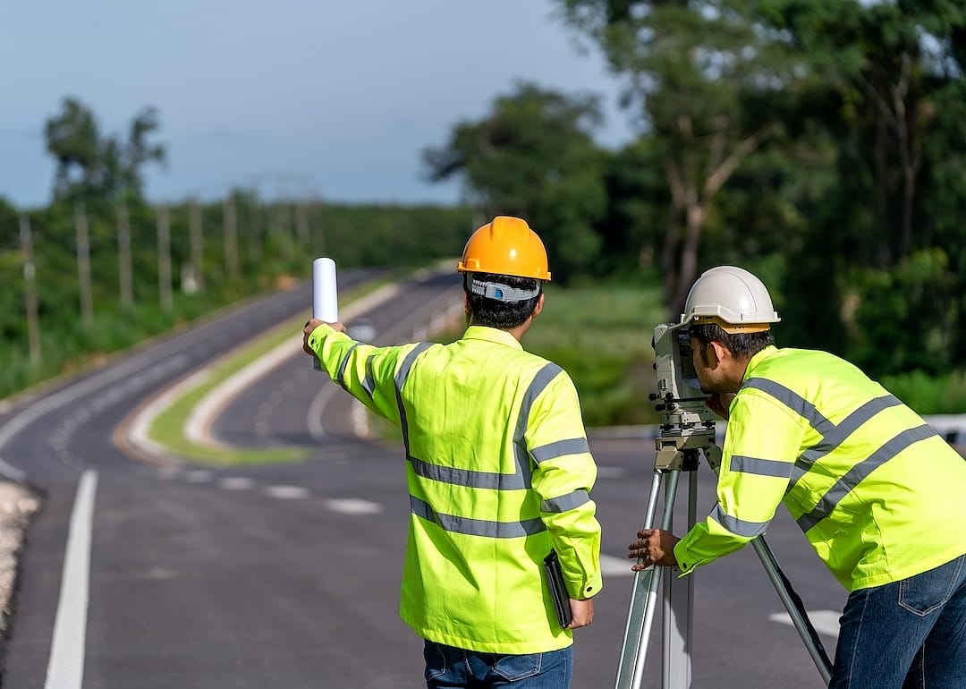 Team of engineers surveying a roadway.