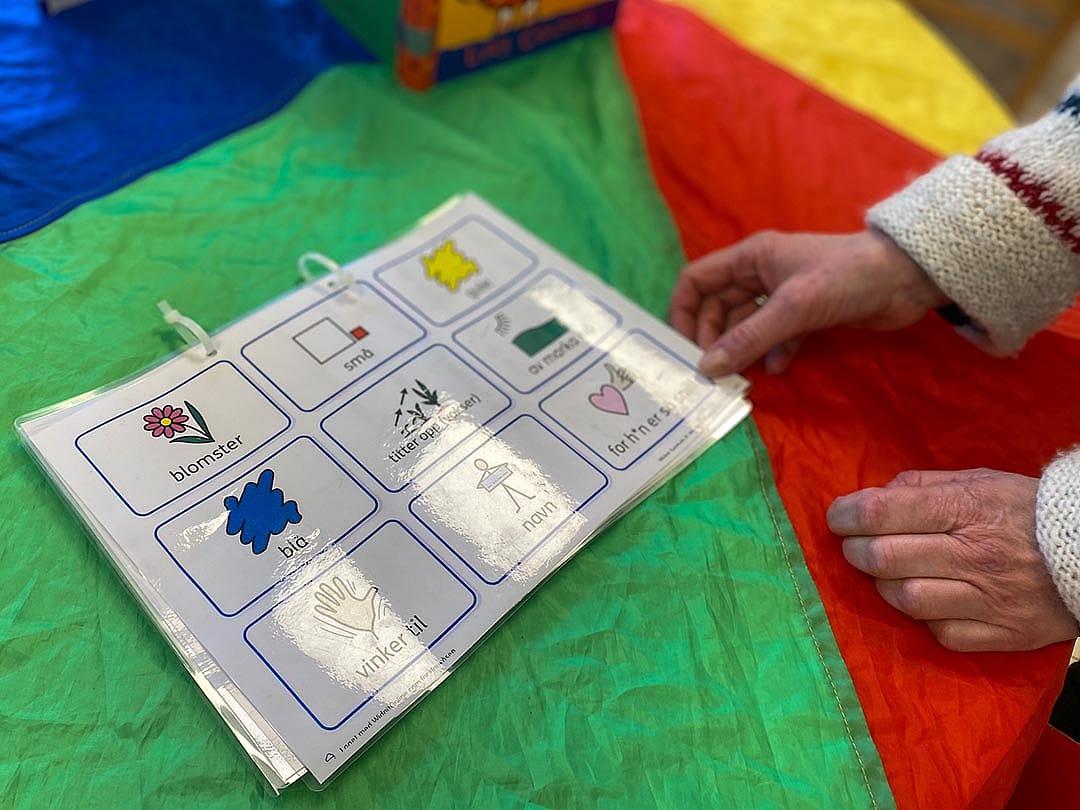 A teacher at a child care program run by Kanvas sets out a packet created to help children learning Norwegian communicate with staff members.