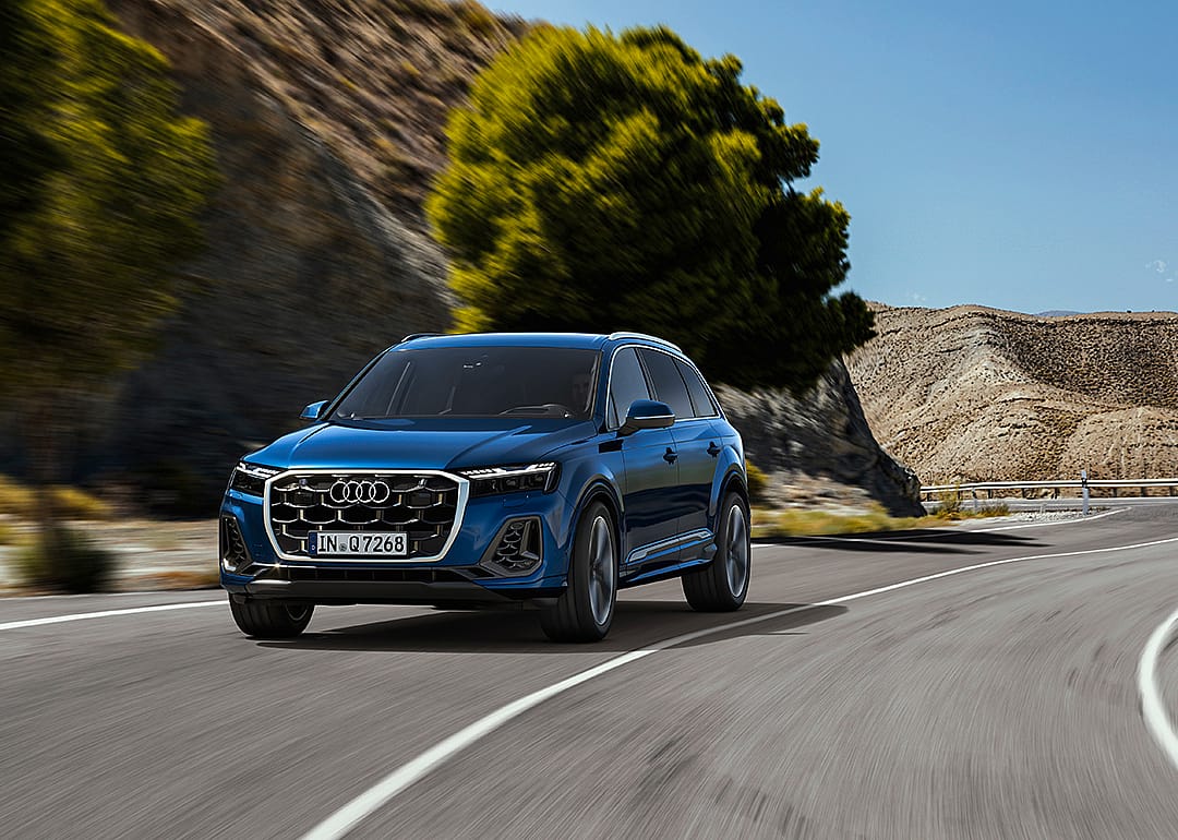 Blue Audi Q7 driving on the road.