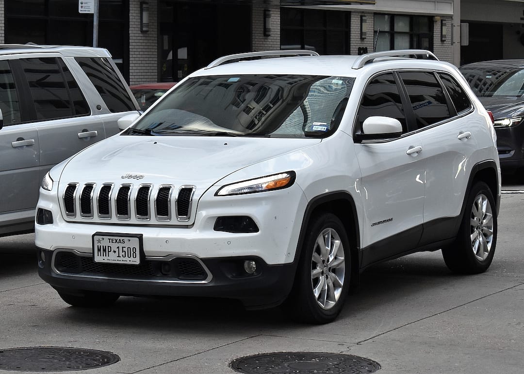  A white Jeep Compass sport utility vehicle, cruising in the downtown financial district of Houston.