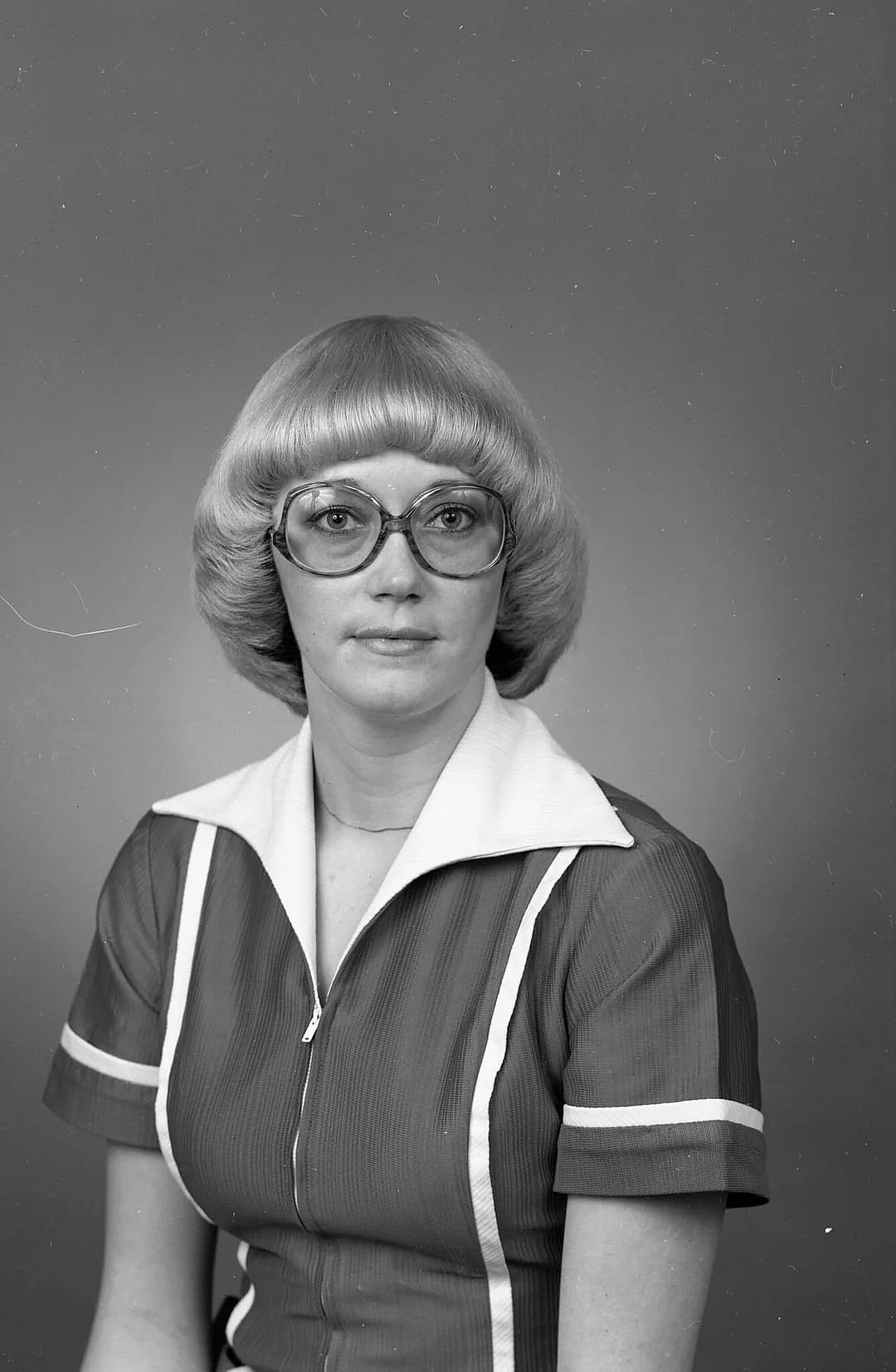 A woman wearing big glasses with a mushroom type haircut was a classic look in 1980.