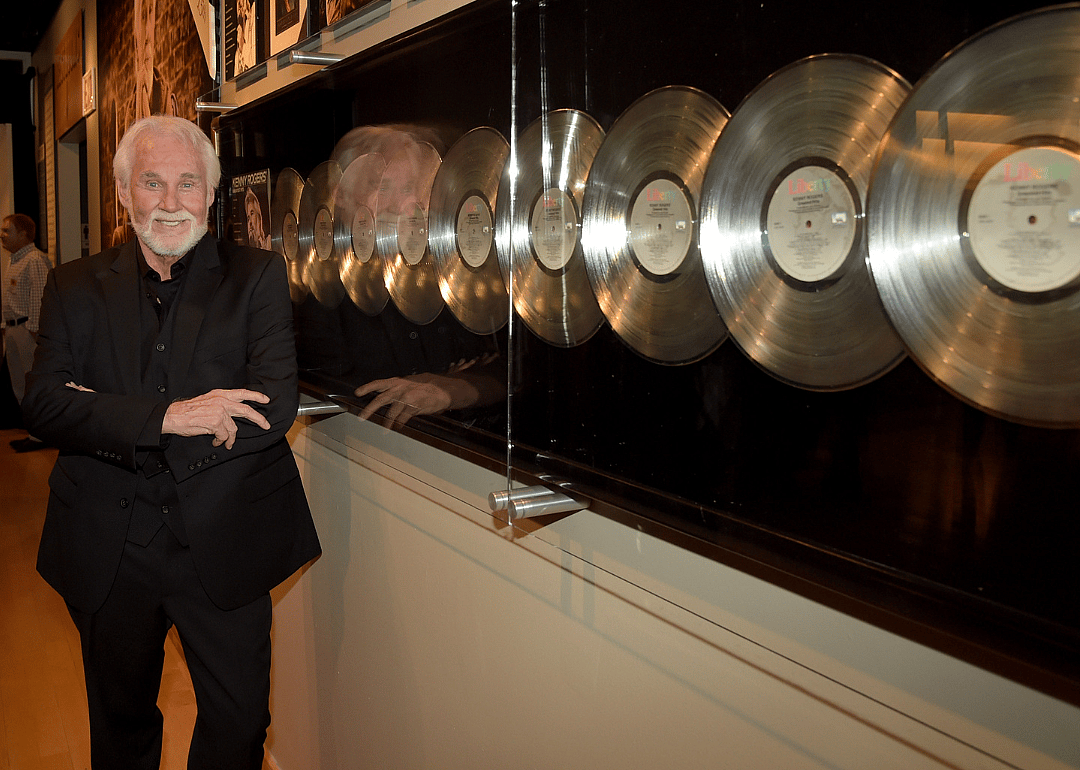 Kenny Rogers poses with gold records at the Country Music Hall of Fame