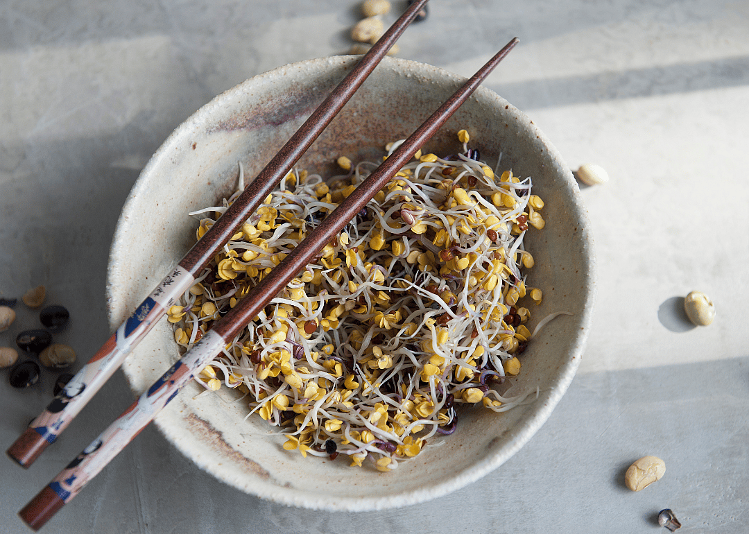 Soybean sprouts in bowl with chopsticks.