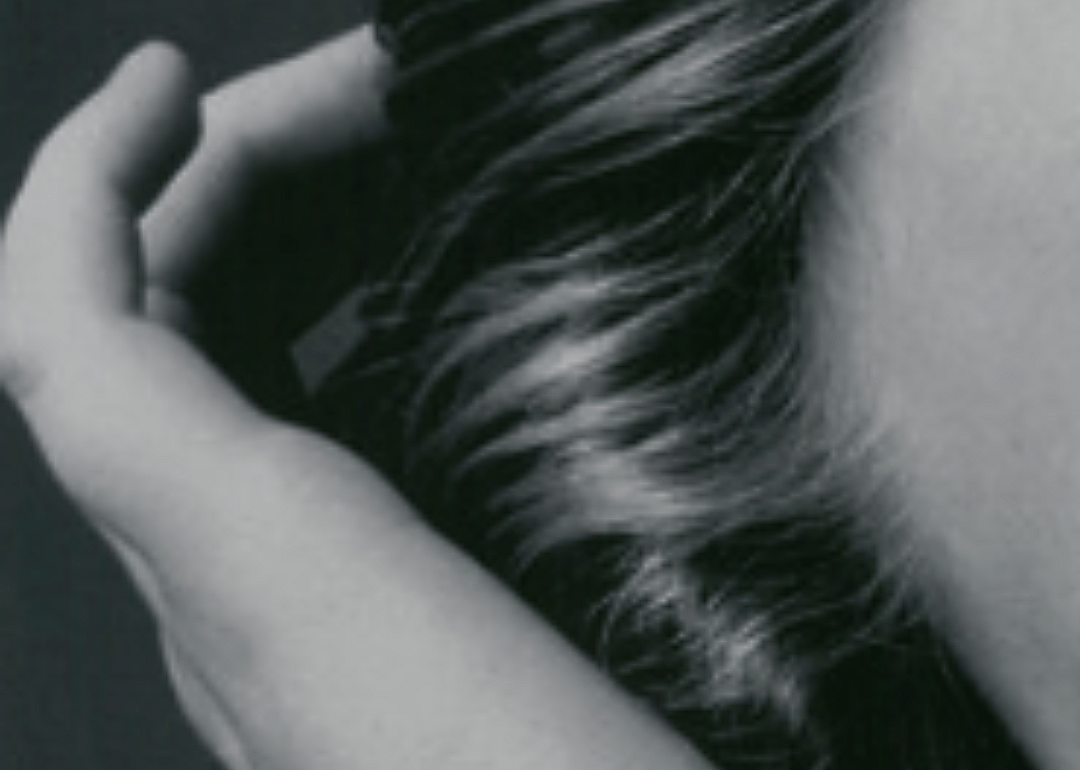 Black-and-white photo of a hand in hair.